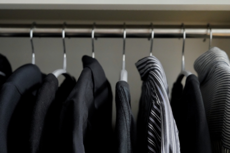 男性用の洋服がハンガーにかけられたクローゼット